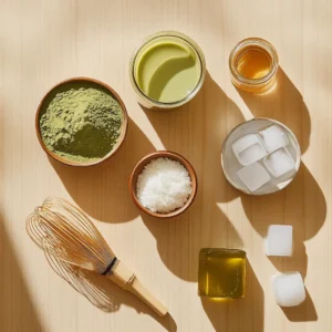 Ingredients for iced matcha latte: matcha powder, milk alternatives, honey, and ice